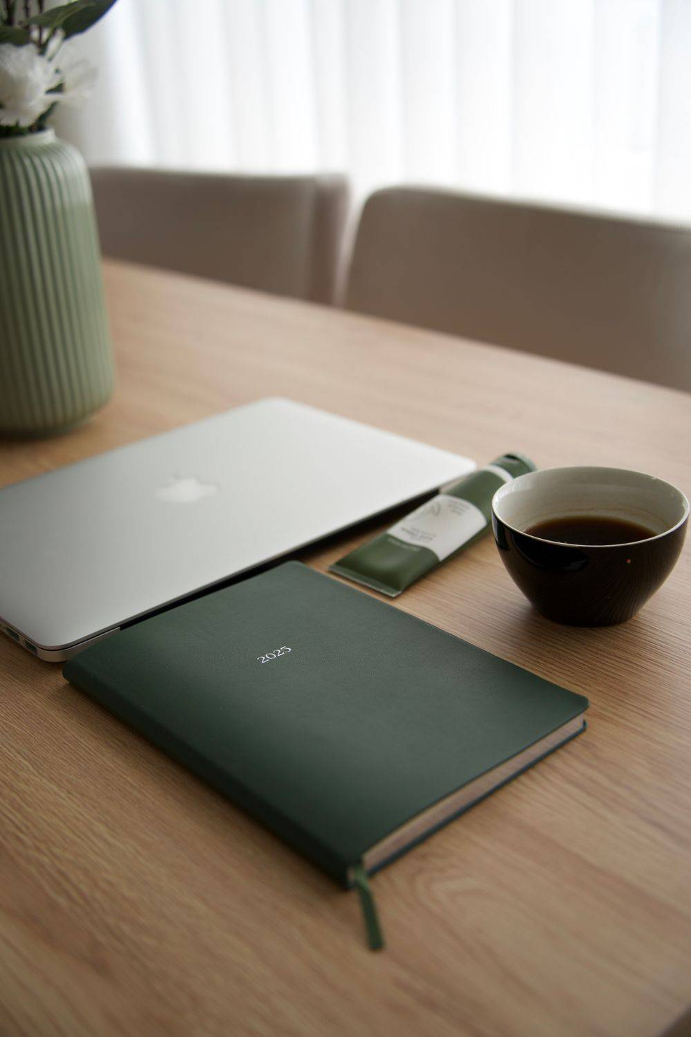 Meja kerja dengan laptop, buku catatan, dan secangkir kopi
