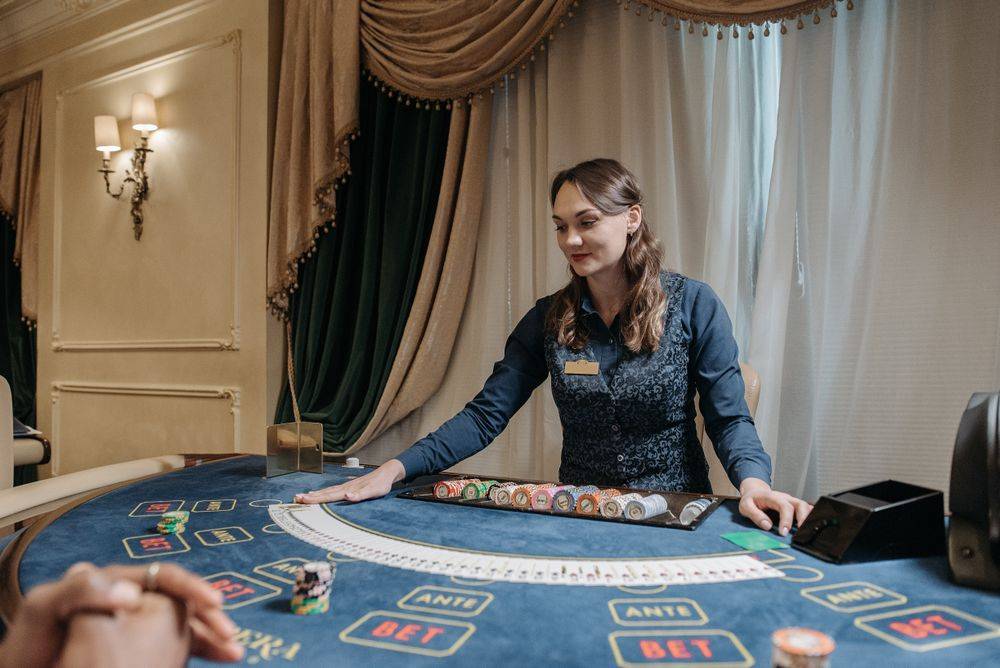 Dealer kasino membagikan kartu di meja dengan chip