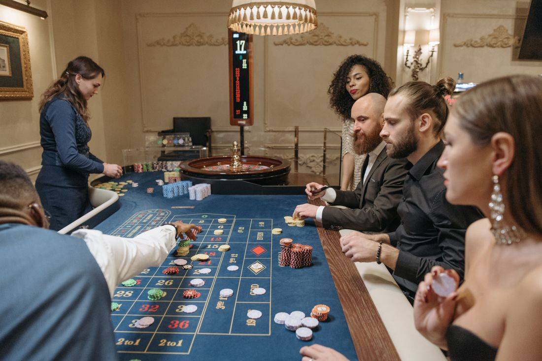 Meja roulette dengan dealer dan pemain di studio live casino