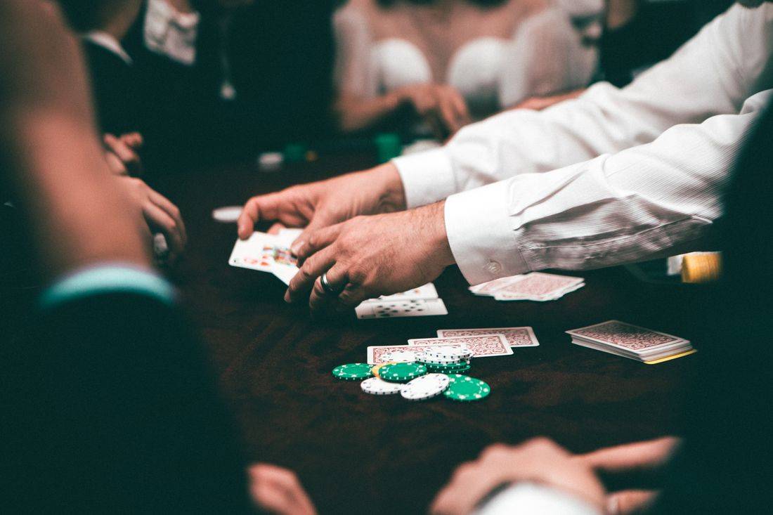 Pemain poker menumpuk chip di atas meja dengan kartu terbuka